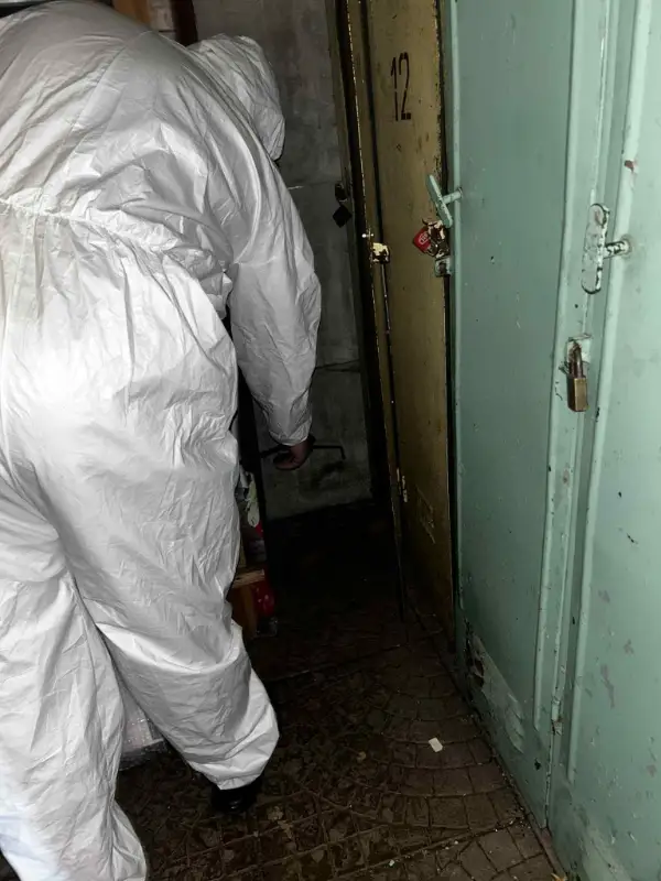 Specjalista DDD w kombinezonie ochronnym wykonuje zabieg odpluskwiania w przejściu między pomieszczeniami – usuwanie pluskiew w Warszawie